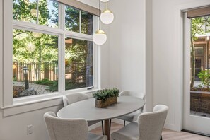 A dining area with a round table, four chairs, and hanging pendant lights. - Basefront Bliss | Capitol Peak Lodge #3119 | 1B/1B (Snowmass Village)