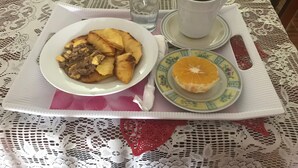 A table with a plate of food, a cup of coffee, and a glass of water. - Laura's Place (Port Antonio)