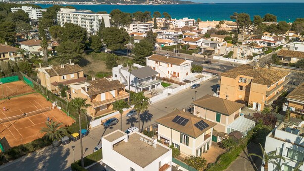 Un quartier résidentiel avec des maisons, un court de tennis et une piscine.