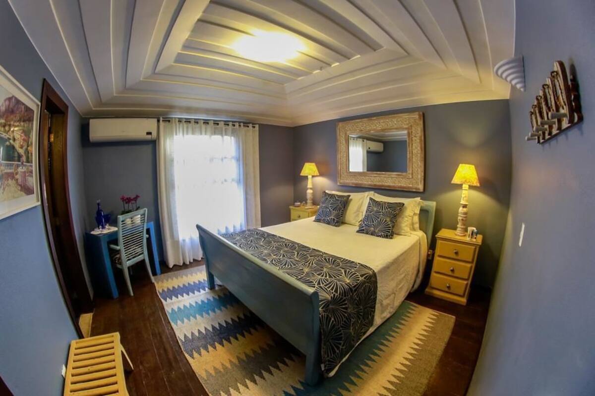 Ein Schlafzimmer mit einem Bett, Nachttischen, einem Spiegel und einem Teppich.