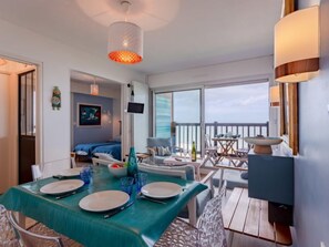 A modern room with a dining area, a bed, and a balcony with a view.