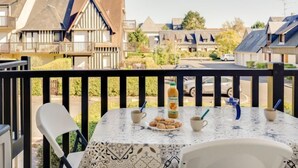 A balcony with a table set for breakfast, overlooking a residential area with houses. - Fleur Marine by Interhome (Cabourg)