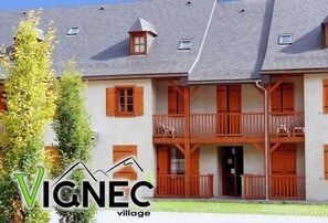 Un bâtiment à deux étages doté de balcons en bois et d’un toit en pente.