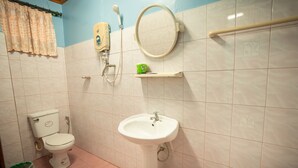 A bathroom with a toilet, sink, mirror, and showerhead. - Salakphet Guesthouse (Luang Prabang)