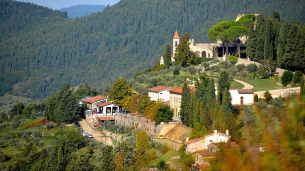 Un village perché sur une colline, doté d’une architecture traditionnelle, avec notamment une église surmontée d’un clocher, le tout entouré d’une végétation luxuriante et traversé par un sentier sinueux.