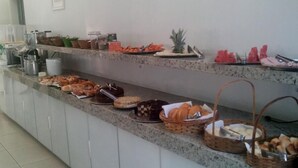 A buffet counter with various food items and condiments.