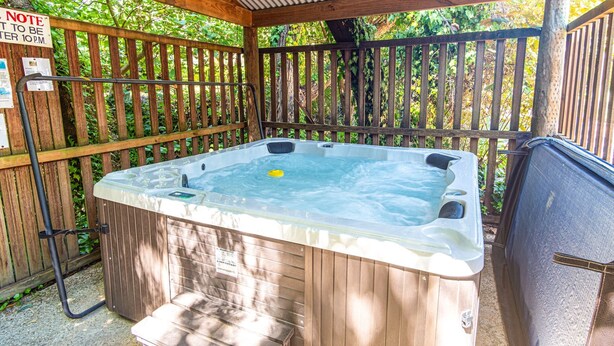 Un bain à remous avec une terrasse en bois et une clôture en bois.