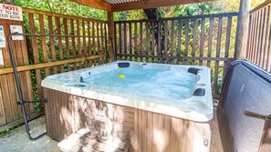 Ein Whirlpool mit Holzterrasse und Holzzaun.