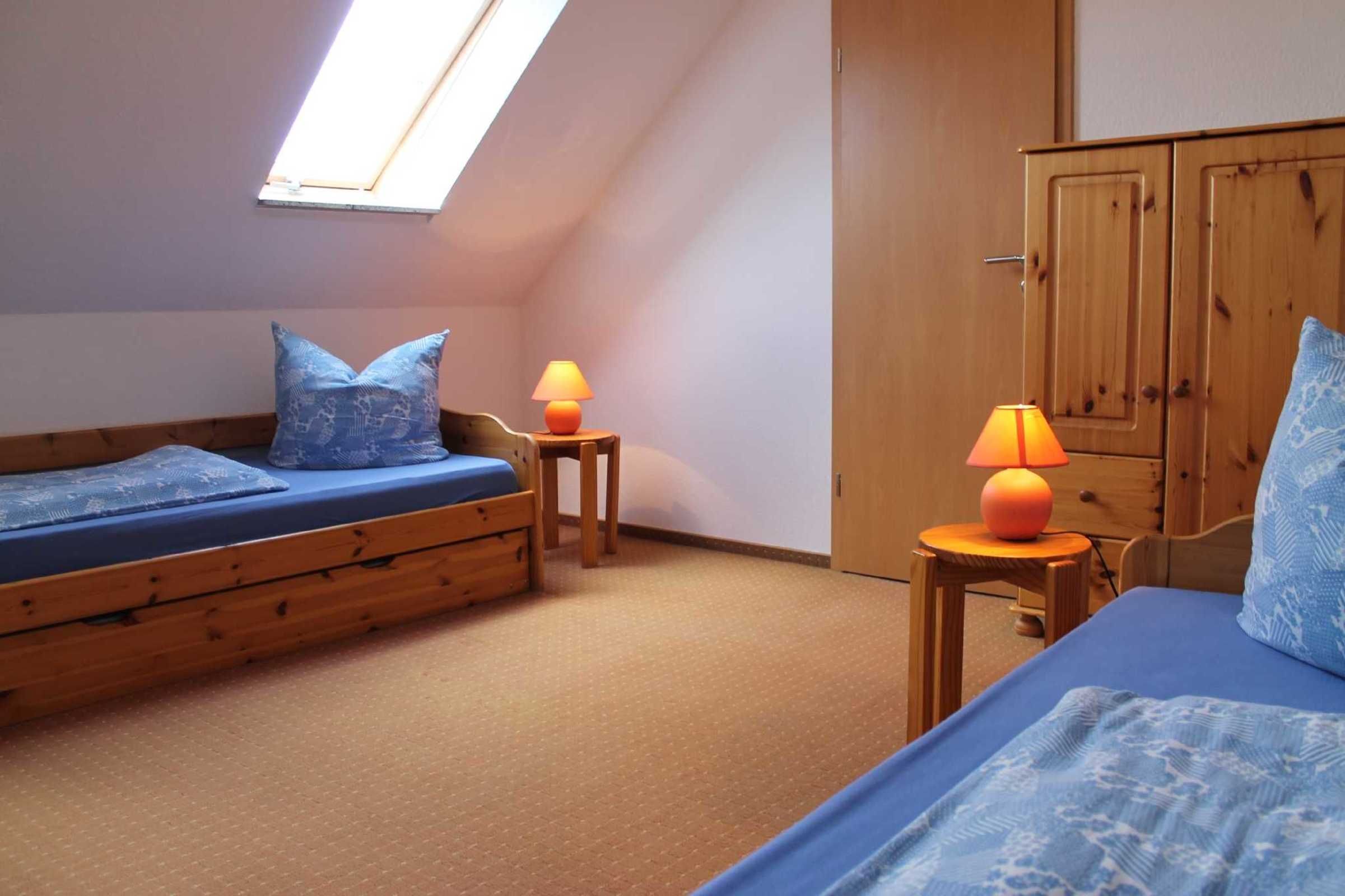 Ein Schlafsaalzimmer mit Hochbett, kleinem Schreibtisch und Kleiderschrank.