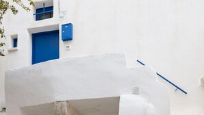 A white building with two blue doors and a potted plant in front. - Terrazza Blu Cobalto by Wonderful Italy (Ostuni)