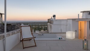 A rooftop terrace with a white chair, a small table, and a lantern. - Terrazza Blu Cobalto by Wonderful Italy (Ostuni)