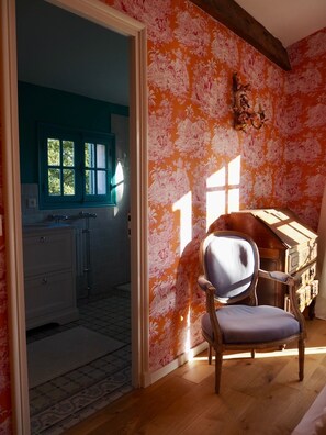 A room with a wooden floor, a chair, a wooden cabinet, and a window with a view of a kitchen. - Idyllic vacation dream (Cavalaire-sur-Mer)