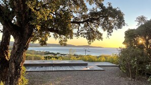 A patio area with a view of the sea and hills.