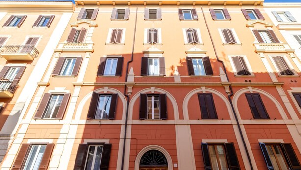 A multi-story building with a consistent architectural style, featuring arched windows and balconies.