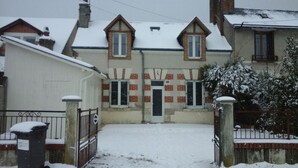 A residential building with a snow-covered entrance, brick facade, and multiple windows. - The house of La Digue, 2 bedrooms with terrace and parking (Blois)