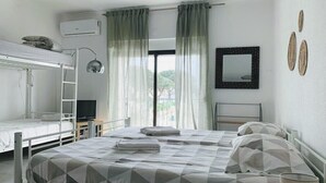 A bedroom with bunk beds, a desk, a chair, a TV, and a window with curtains. - Sublime Sun & Van, By Meco Stays (Sesimbra)