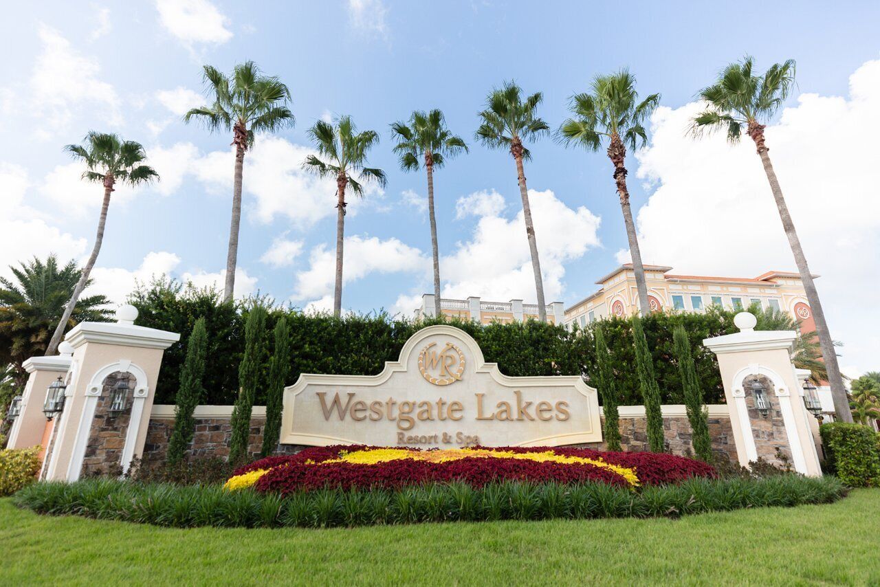 Placa para Westgate Lakes Resort & Spa, com palmeiras e céu azul ao fundo.