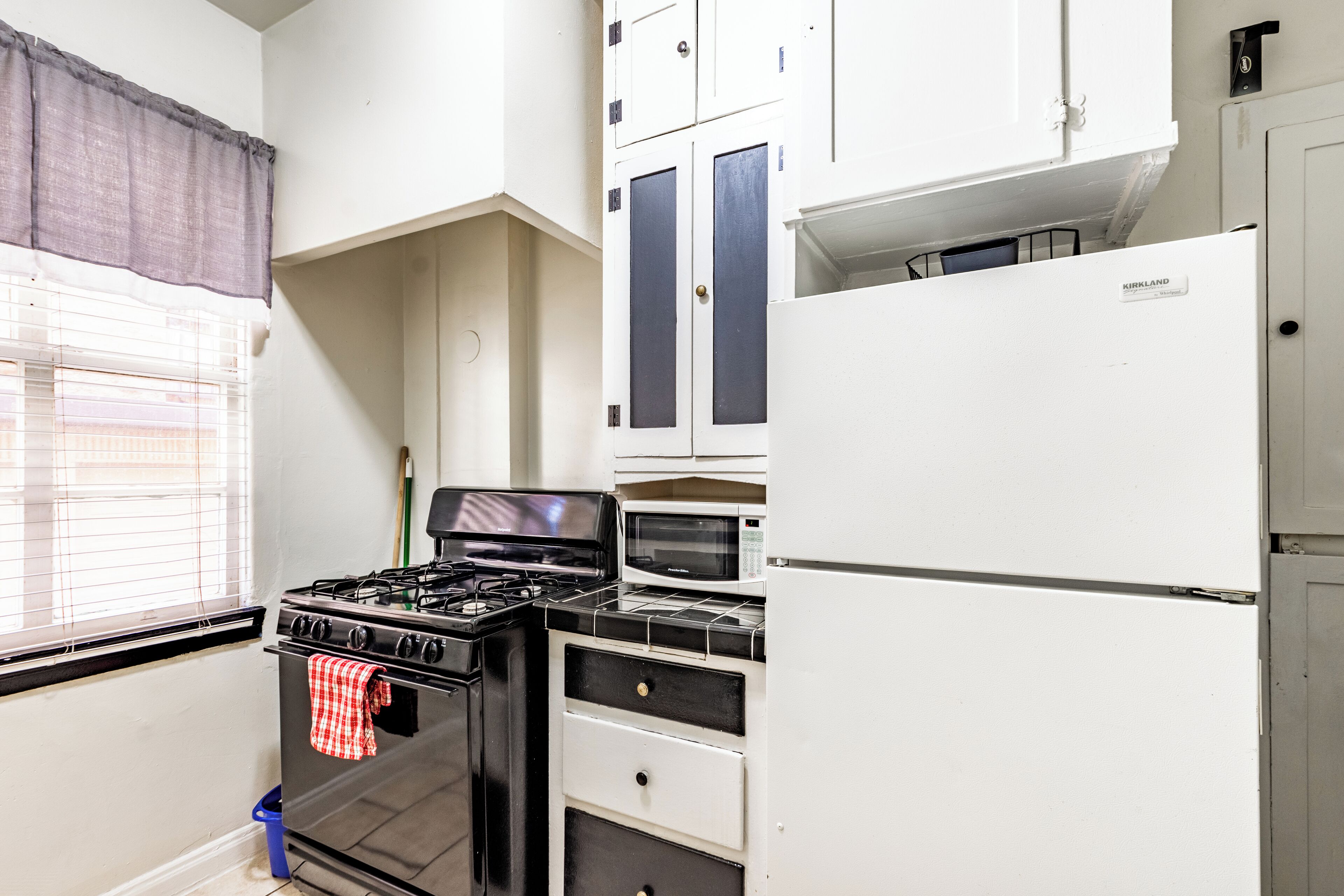 A kitchen with a stove, microwave, and refrigerator.