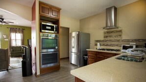 Een moderne keuken met inbouwapparatuur, een groot eiland en een zithoek met een bank.