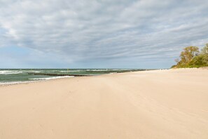 A beach with a sandy shore and a rocky breakwater.
