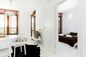 Een moderne slaapkamer met een bed, nachtkastje en een spiegel.