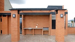 An outdoor barbecue area with a brick wall, a sink, and a grill. - FLAT CHAPINERO CENTRAL (Bogotá)