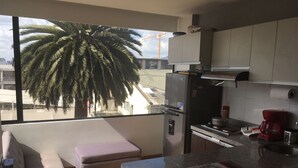 A modern kitchen with a large window, a built-in oven, a refrigerator, and a coffee maker. - FLAT CHAPINERO CENTRAL (Bogotá)