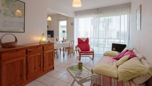 Una sala acogedora con un sofá, una mesa de comedor y una zona de cocina.