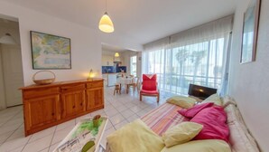 Una sala de estar con un sofá, una televisión y un comedor con mesa y sillas.