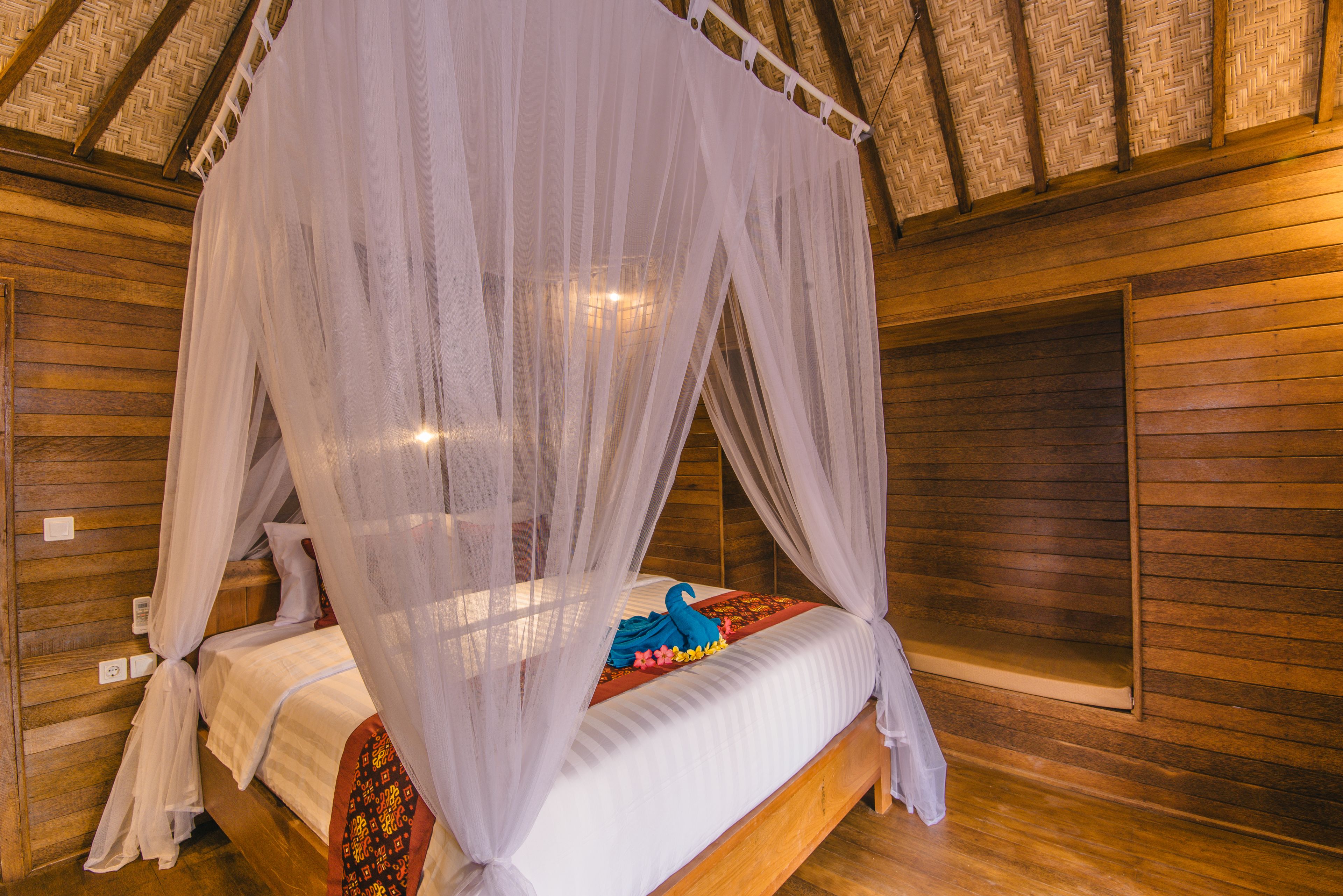 A wooden room with a bed under a canopy.