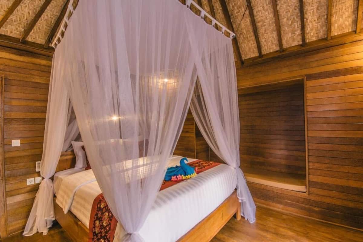 Una habitación de madera con una cama bajo un dosel.
