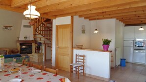 A cozy interior with a dining area, kitchen, and wooden staircase. - Traditional cottage with terrace, pets allowed (La Tuilière)
