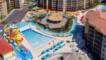 Resort com piscina central, toboágua e várias áreas de estar com guarda-sóis.
