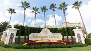 Une enseigne indiquant l’emplacement du Westgate Lakes Resort & Spa, avec des palmiers et un ciel dégagé en arrière-plan.