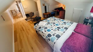Een slaapkamer met een bed, een bureau, een stoel en een klein tafeltje.