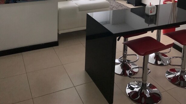 A modern living room with a large abstract painting, a white sofa, a glass coffee table, and a TV mounted on the wall. - APTO  LOFT   PEREIRA (Pereira)