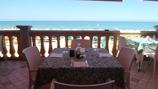 Ein Esstisch mit Blick auf Strand und Meer.
