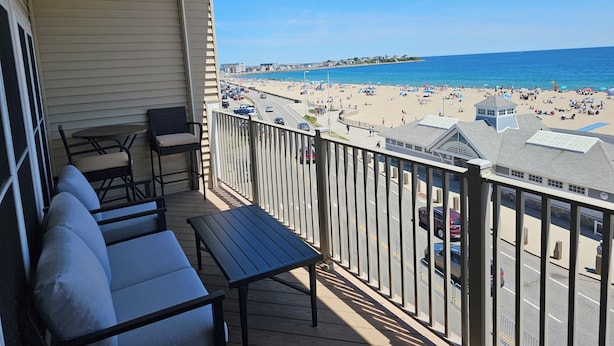 Un balcon avec vue sur une plage et l’océan.