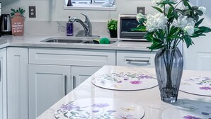 Una cocina moderna con armarios blancos, horno empotrado y ventana con vistas.