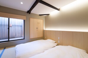 A room with two beds, a wooden wardrobe, and a window with blinds. - Mibu-Juku (Kyoto)