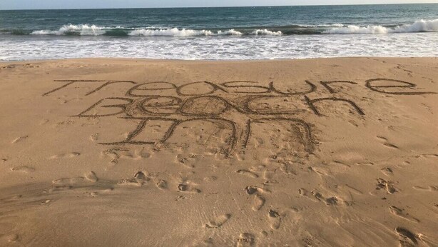 A beach with the words "Treasure Beach Inn" written in the sand. - Treasure Beach Inn and Bar Room #1: Driftwood Queen (St. Elizabeth Parish)