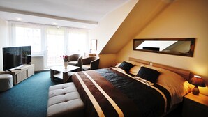 Une chambre d’hôtel avec un lit, une télévision, un bureau et une chaise.