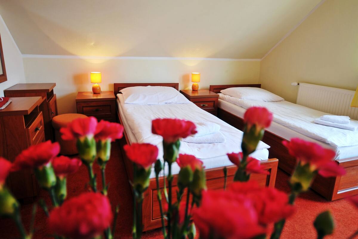 Una habitación de hotel con dos camas, muebles de madera y lámparas de noche.