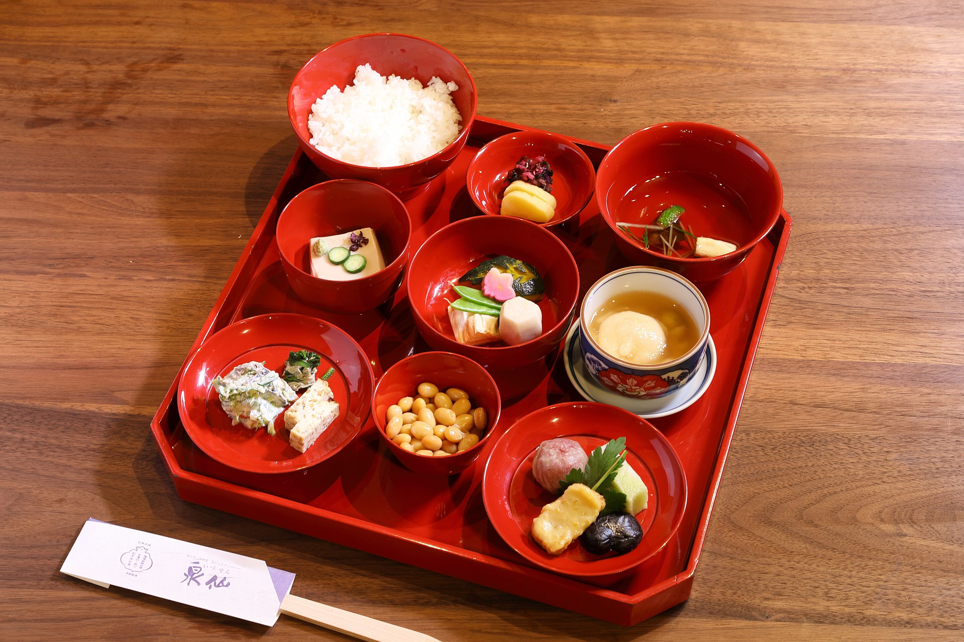 A tray with various food items including rice, tofu, and pickled vegetables.