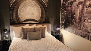 Un dormitorio con una cama grande, un mural de paisaje urbano y un techo abovedado singular.