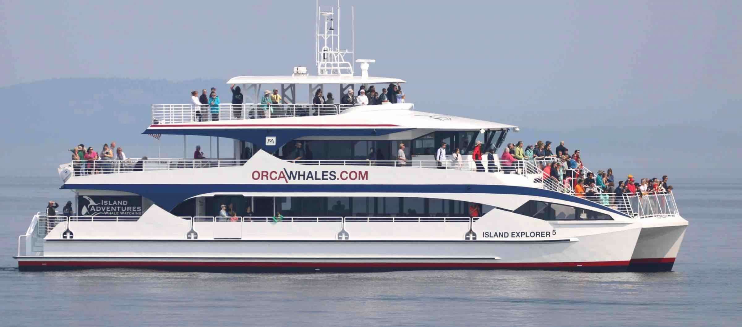 Un grand bateau de tourisme doté de plusieurs ponts et transportant une foule de passagers.