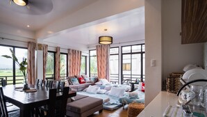 A spacious living area with a large window, a dining table, and a sofa. - Casa Herminia Baler (Baler)