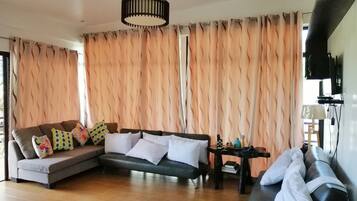 A living room with a sofa, a coffee table, and a television.
