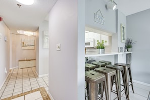 A hallway with a tiled floor and a painting on the wall. - Pool Access, Walk to Manatee Beach: Coastal Condo (Holmes Beach)
