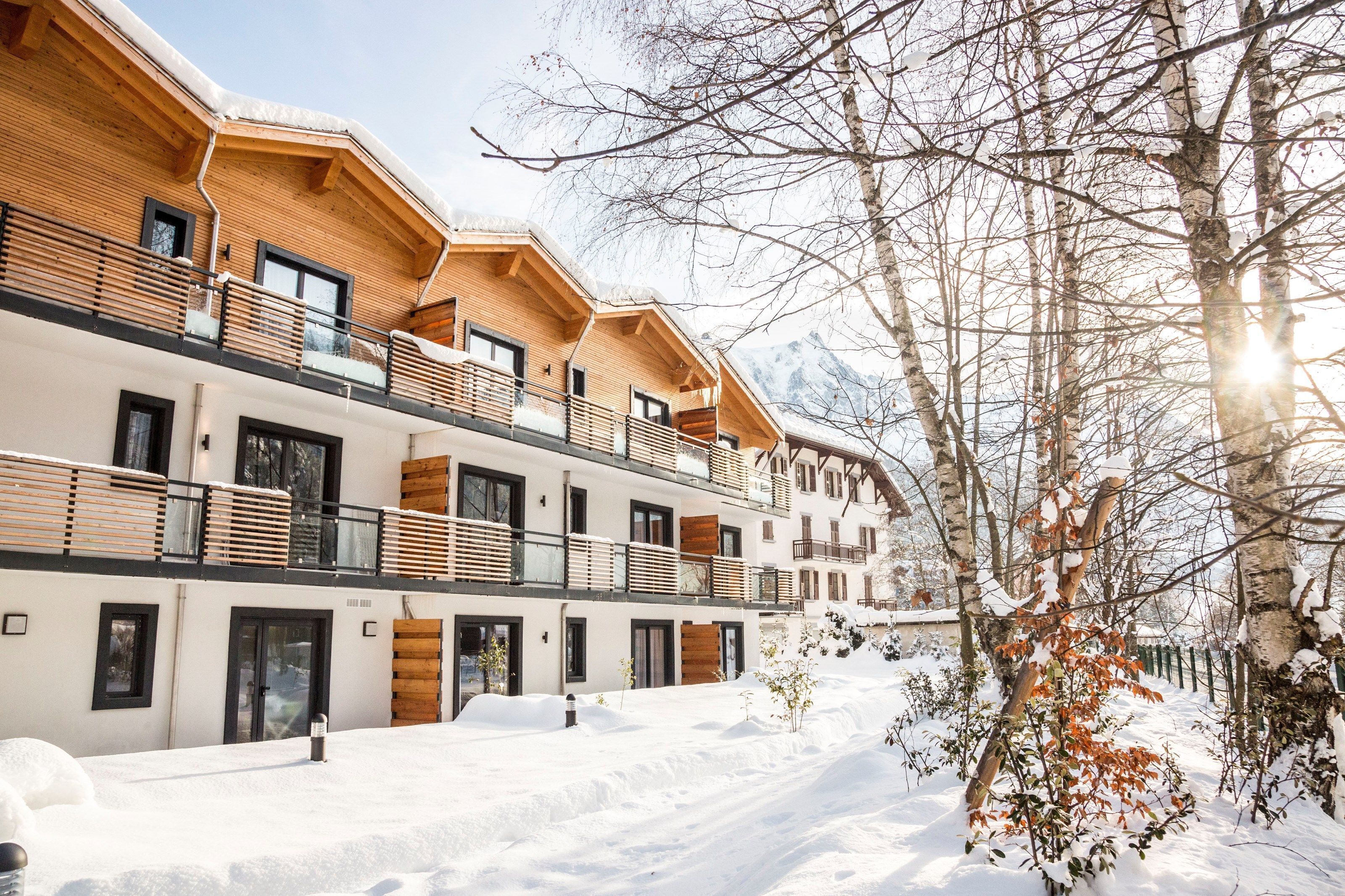 A multi-story hotel with wooden balconies and a snowy landscape.